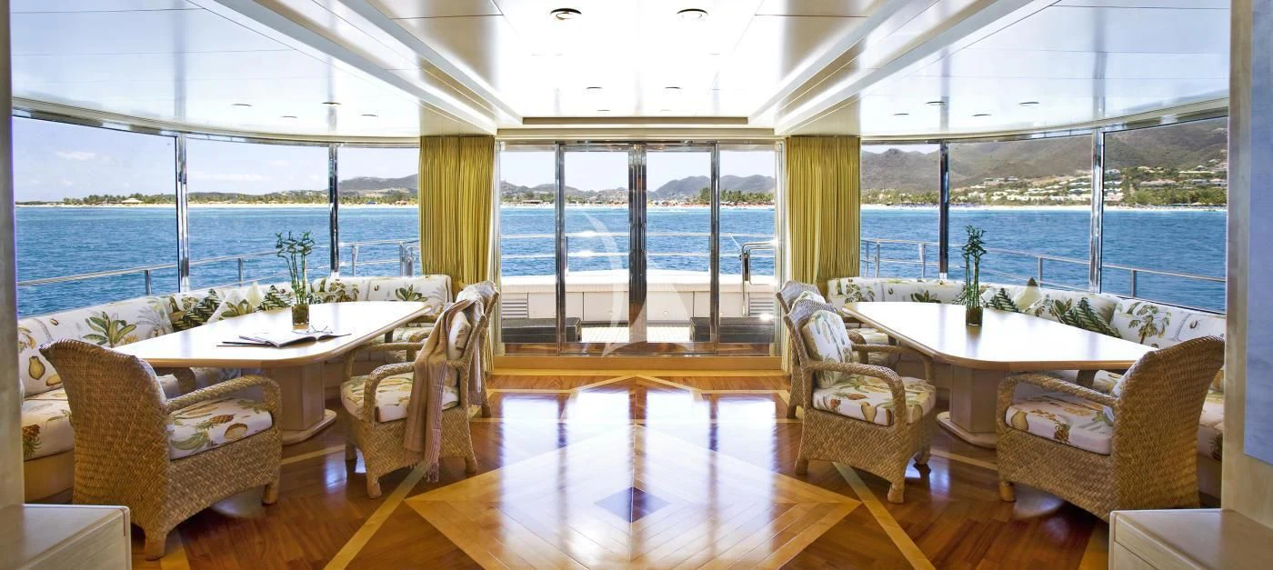 a room with a table chairs and a large window aboard TE MANU Yacht for Charter