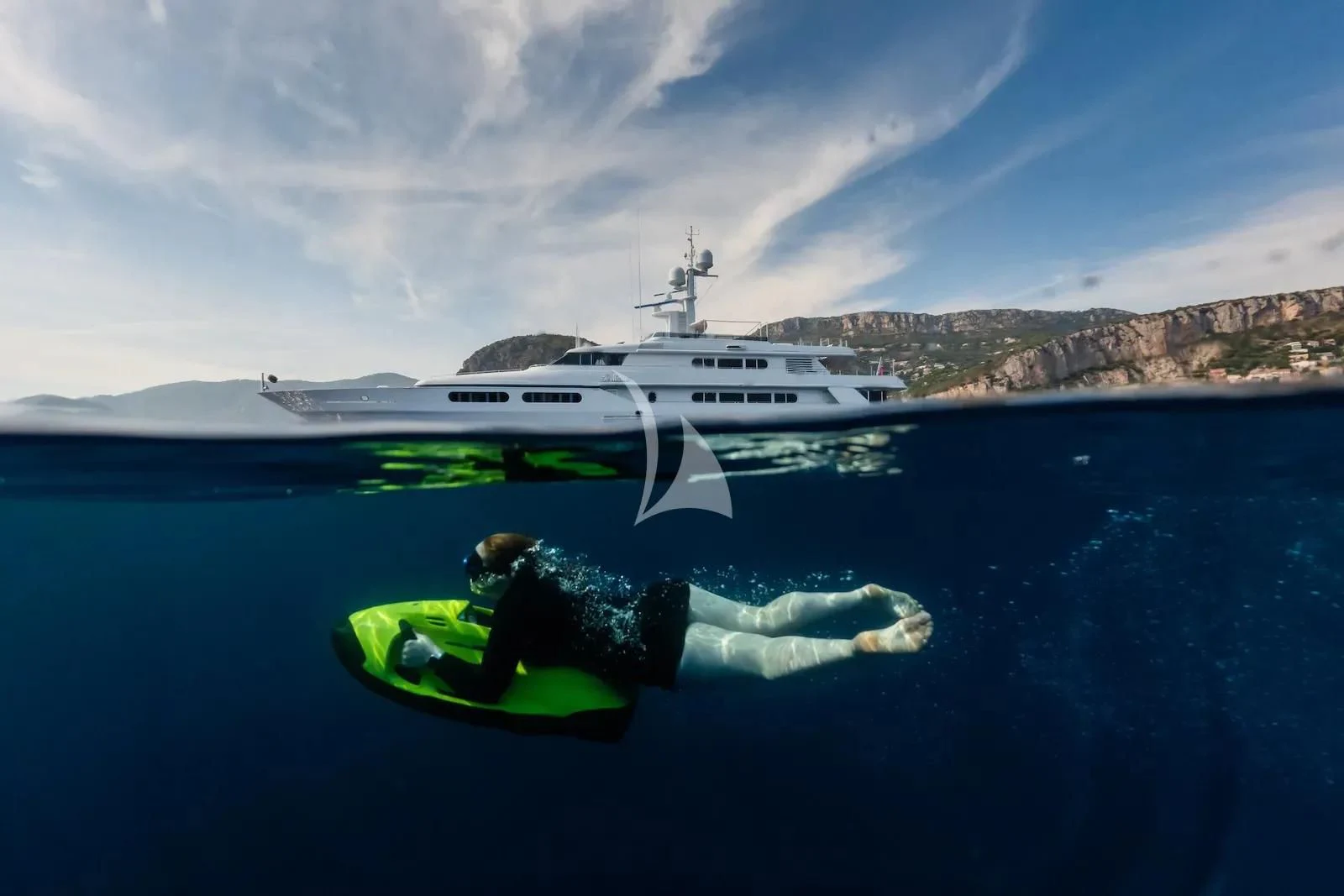a person lying on a boat in the water with a helicopter in the background aboard TE MANU Yacht for Charter
