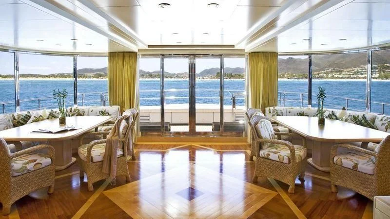 a room with a table chairs and a large window aboard TE MANU Yacht for Charter