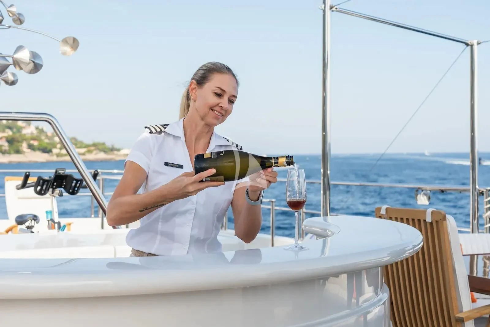 a person holding a bottle of wine aboard TE MANU Yacht for Charter