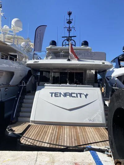 a large white boat with a red stripe on the front aboard TENACITY Yacht for Sale