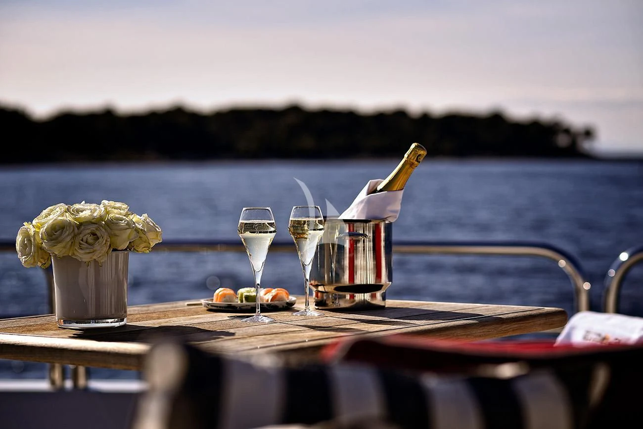 a table with glasses and a vase with flowers on it aboard TENACITY Yacht for Sale