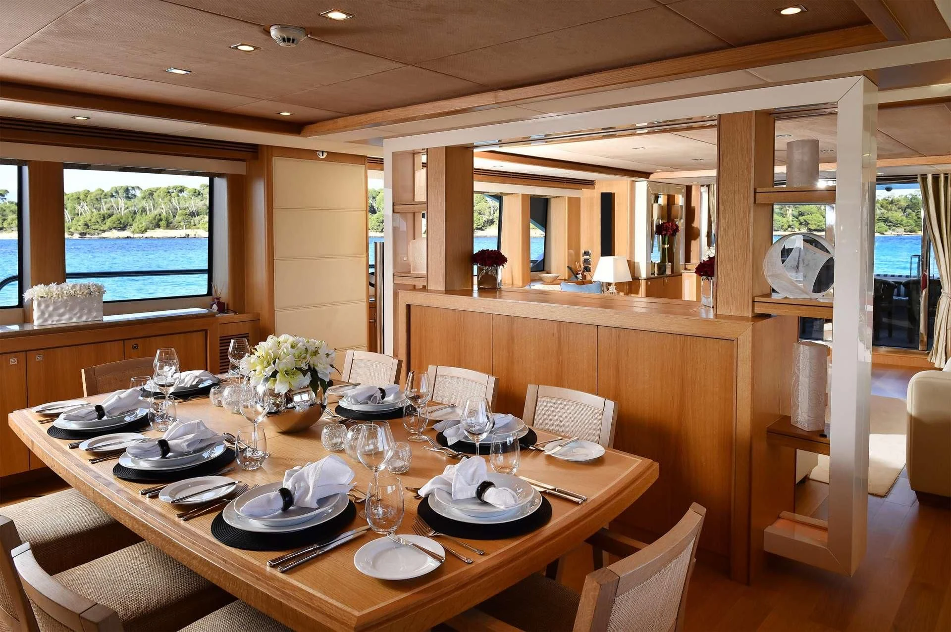 a dining table with plates and glasses aboard TENACITY Yacht for Sale