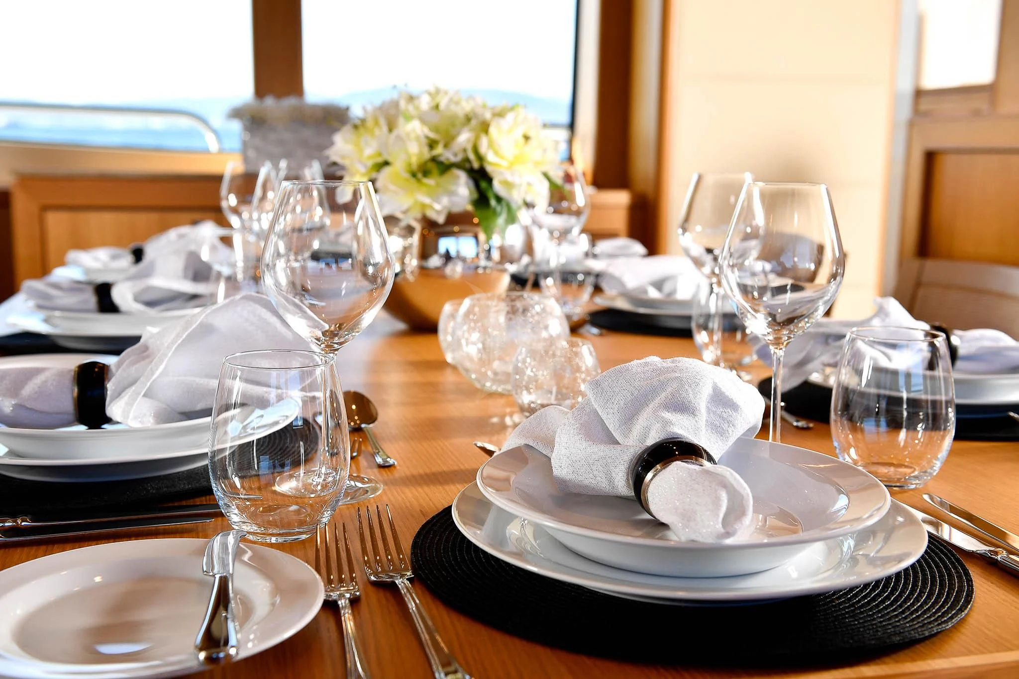 a table with plates and glasses aboard TENACITY Yacht for Sale