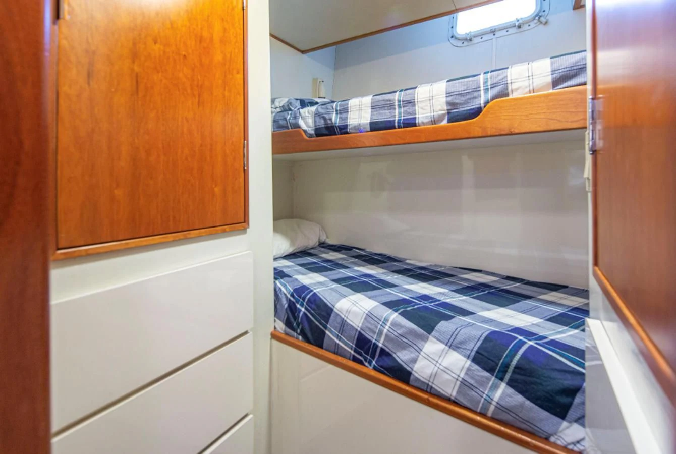 a bed with a blue and white striped blanket aboard GOLDEN EAGLE Yacht for Sale