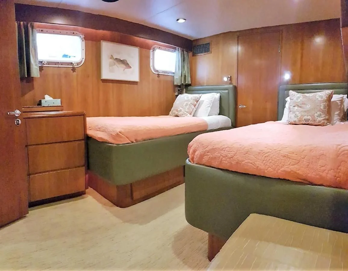 a room with a bed and a dresser aboard GOLDEN EAGLE Yacht for Sale