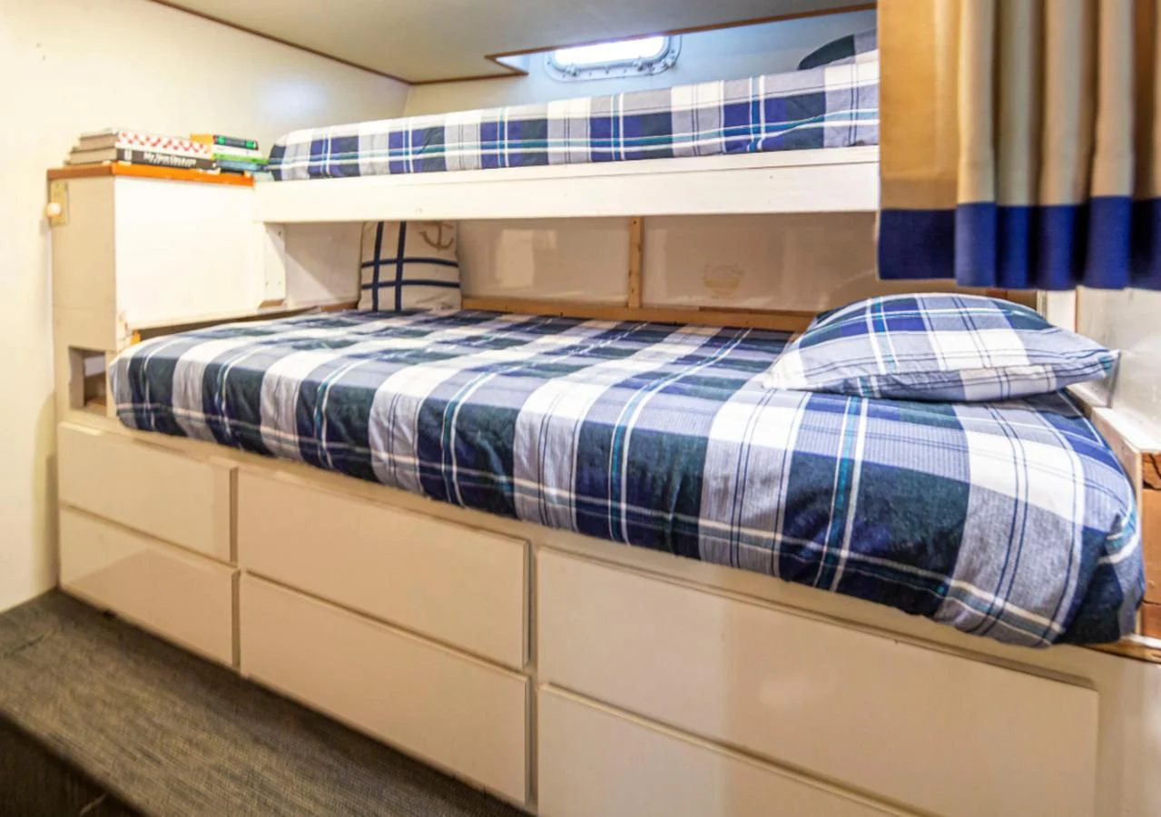 a bed with a blue and white striped blanket aboard GOLDEN EAGLE Yacht for Sale