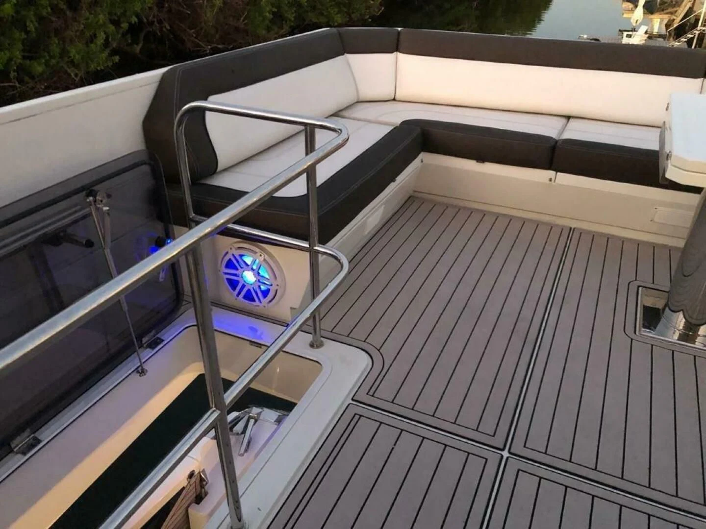 a deck with a railing and a railing with a railing and a body of water and trees in aboard GODSPEED Yacht for Sale