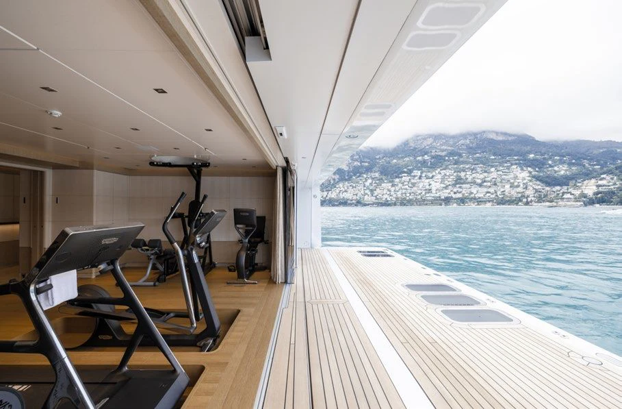a boat deck with a laptop on it and a body of water in the background aboard ENERGY Yacht for Sale