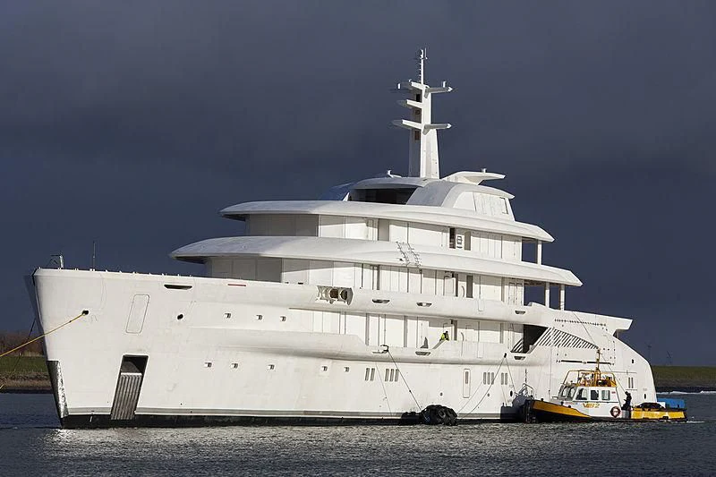a large white ship with a smaller boat in it with Benalmádena Stupa in the background aboard ENERGY Yacht for Sale
