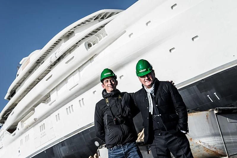 two men standing in front of a large airplane aboard ENERGY Yacht for Sale