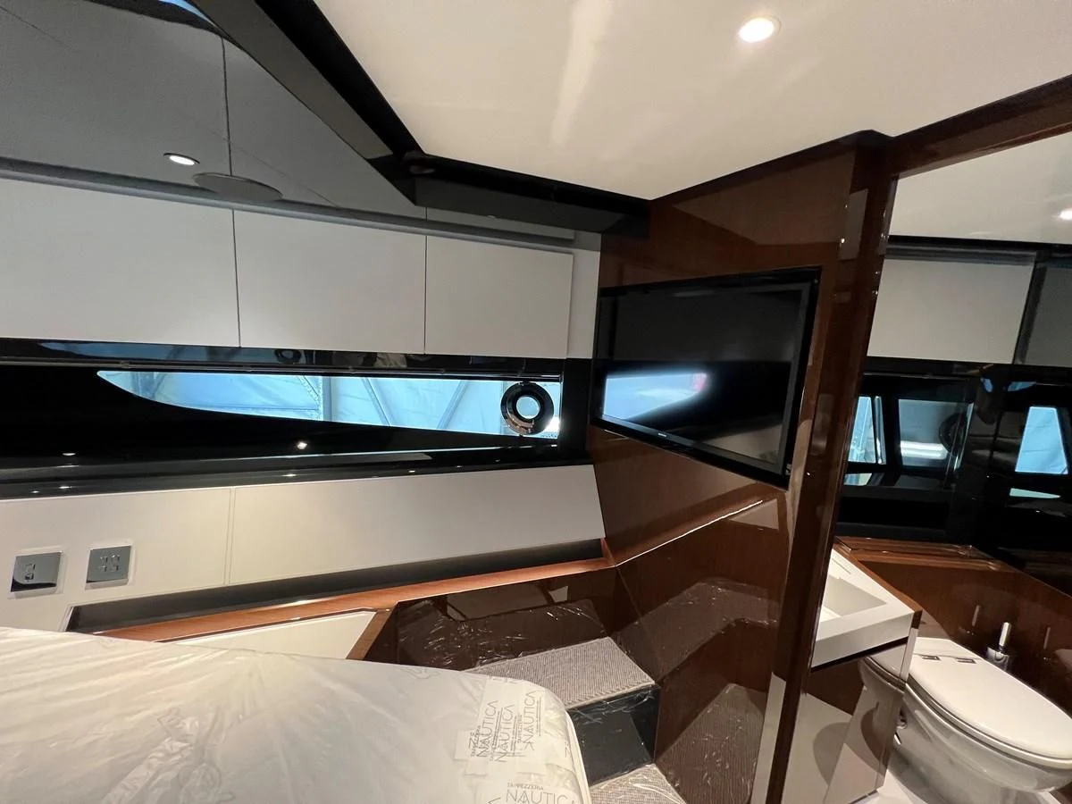 a room with a bed and tv aboard RIVA 68' DIABLE Yacht for Sale