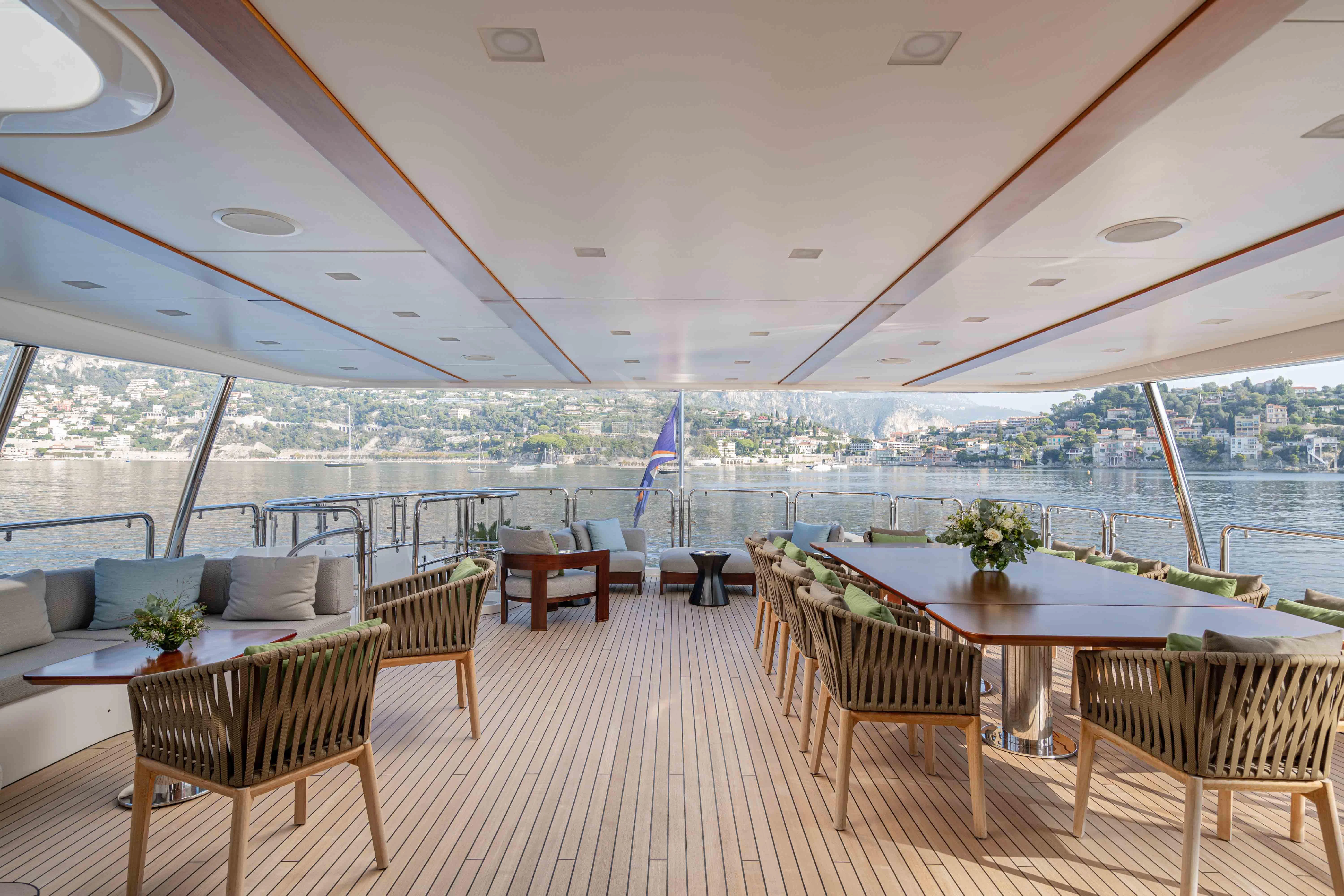 a large room with a table and chairs and a large window aboard EDESIA Yacht for Sale