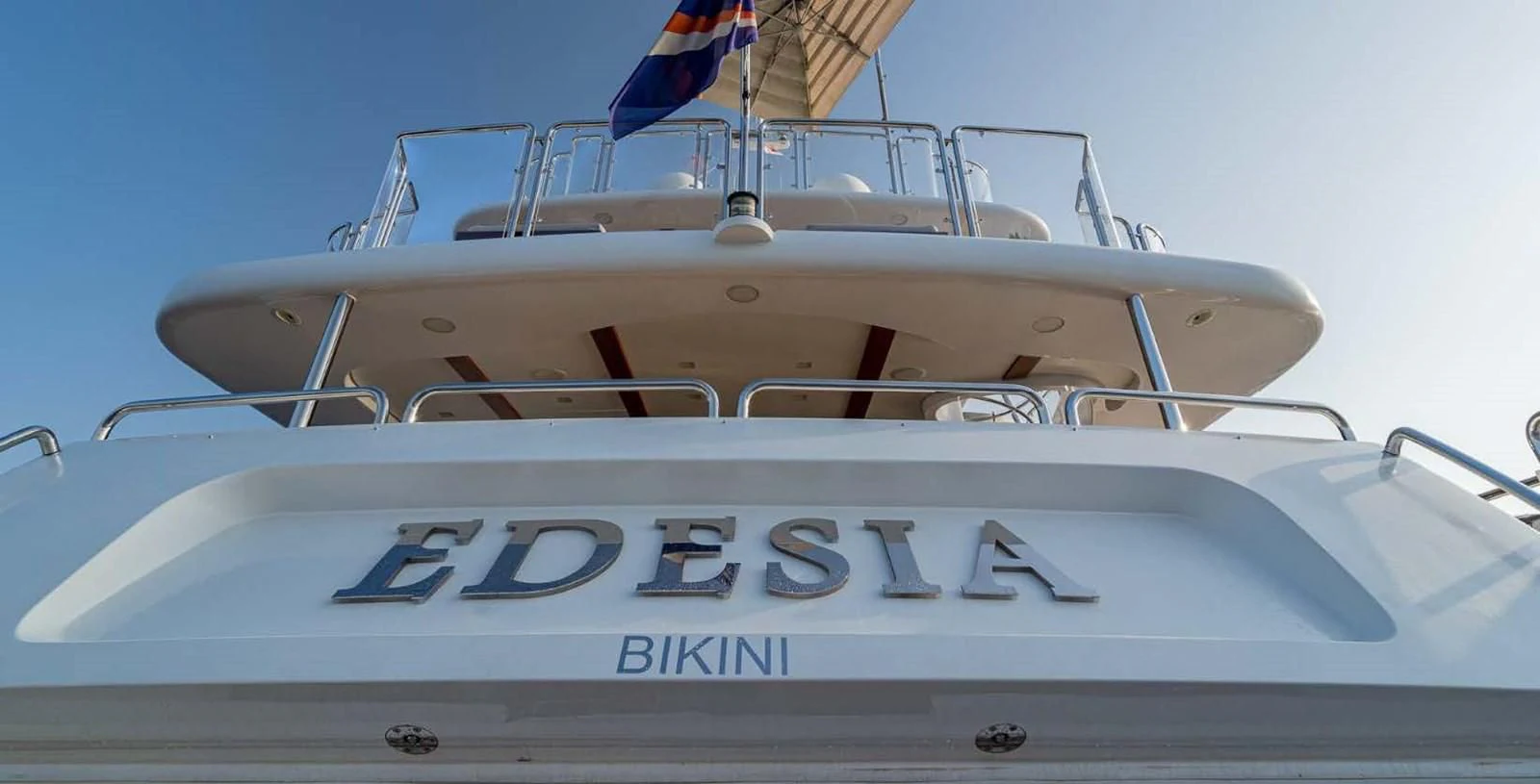 a white boat with a blue and white striped front aboard EDESIA Yacht for Sale