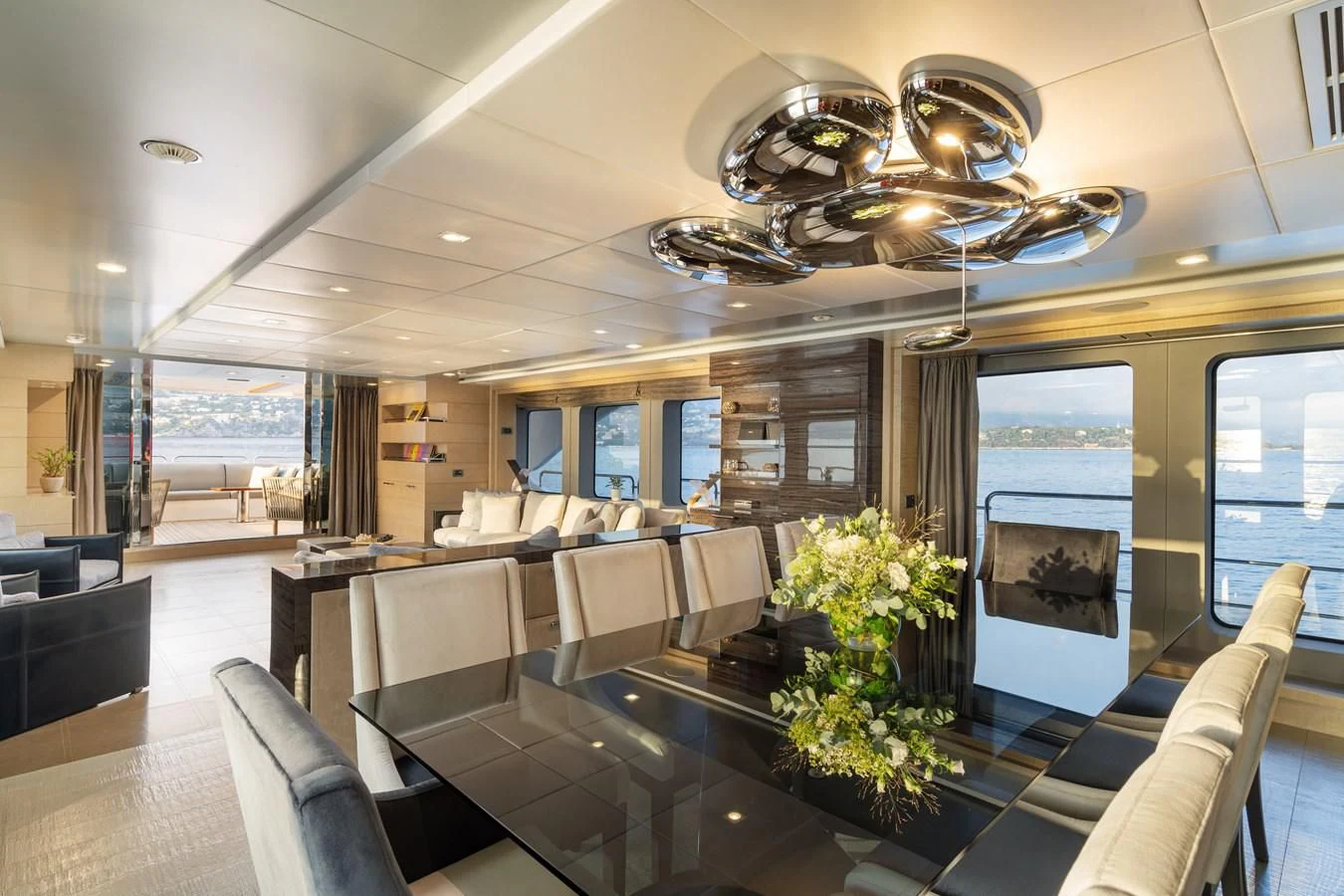a large room with a chandelier and a table with chairs aboard EDESIA Yacht for Sale