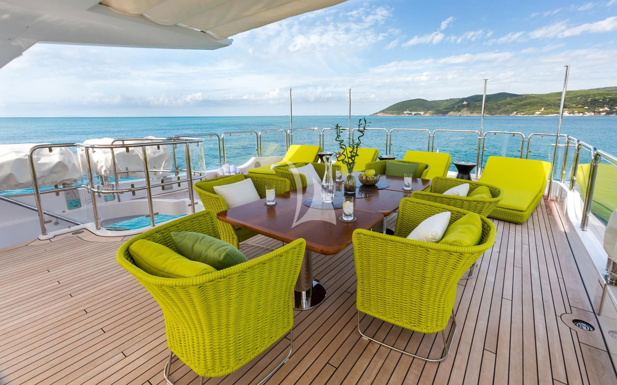 a table and chairs on a deck overlooking a body of water aboard EDESIA Yacht for Sale
