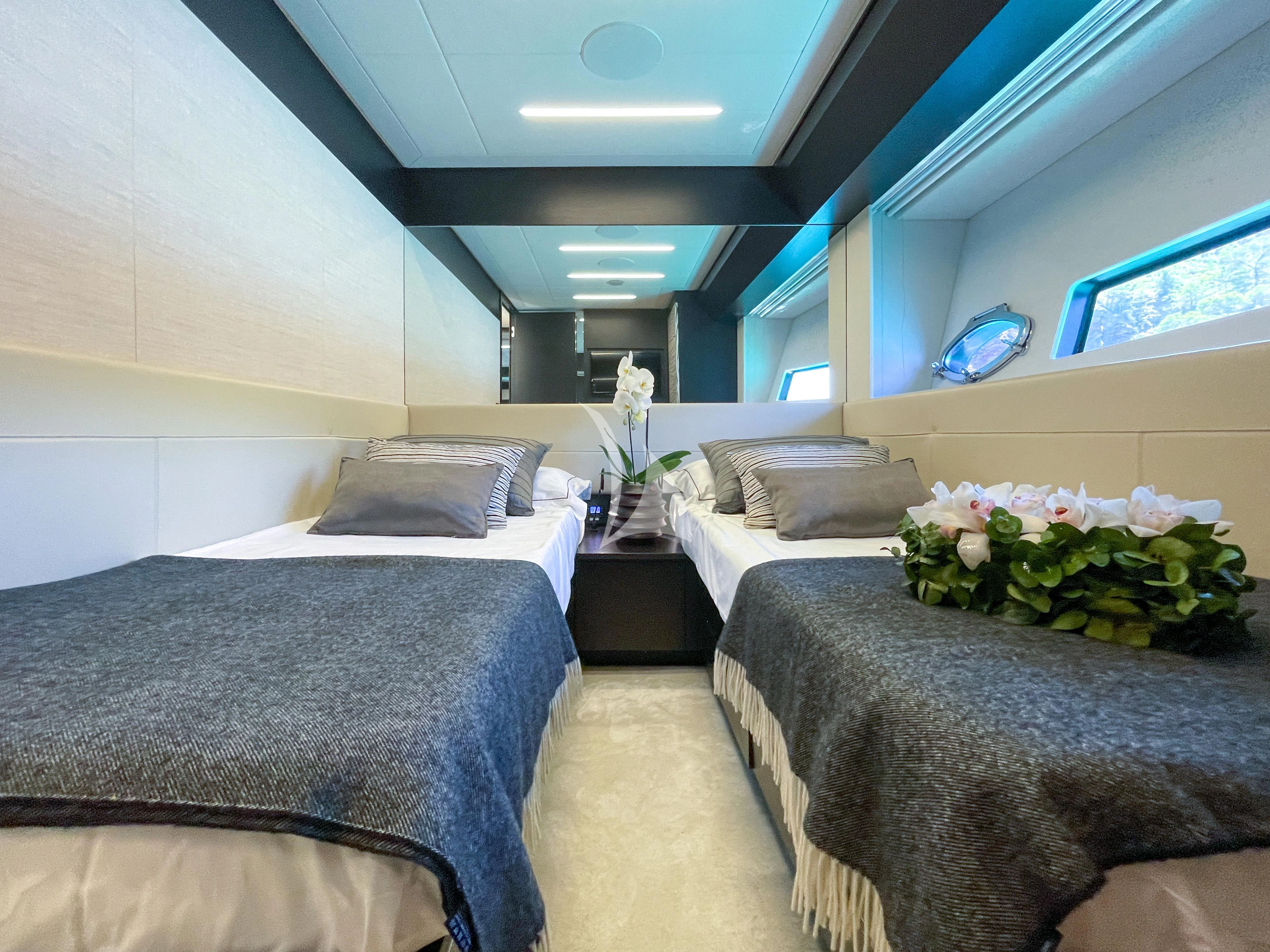 a room with beds and a tv aboard BEYOND Yacht for Sale