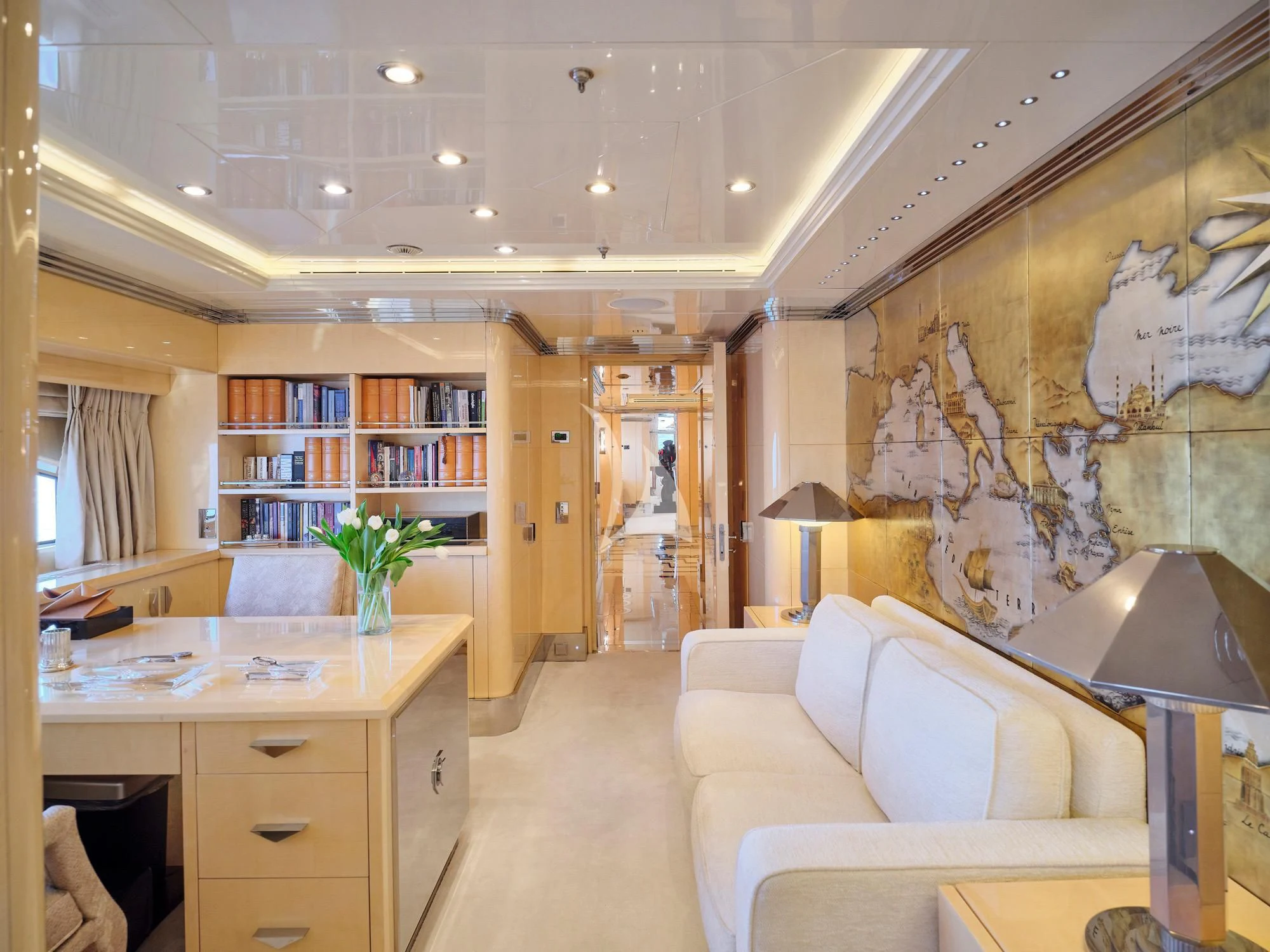a room with a couch and a table with books on it aboard SUNDAY Yacht for Charter
