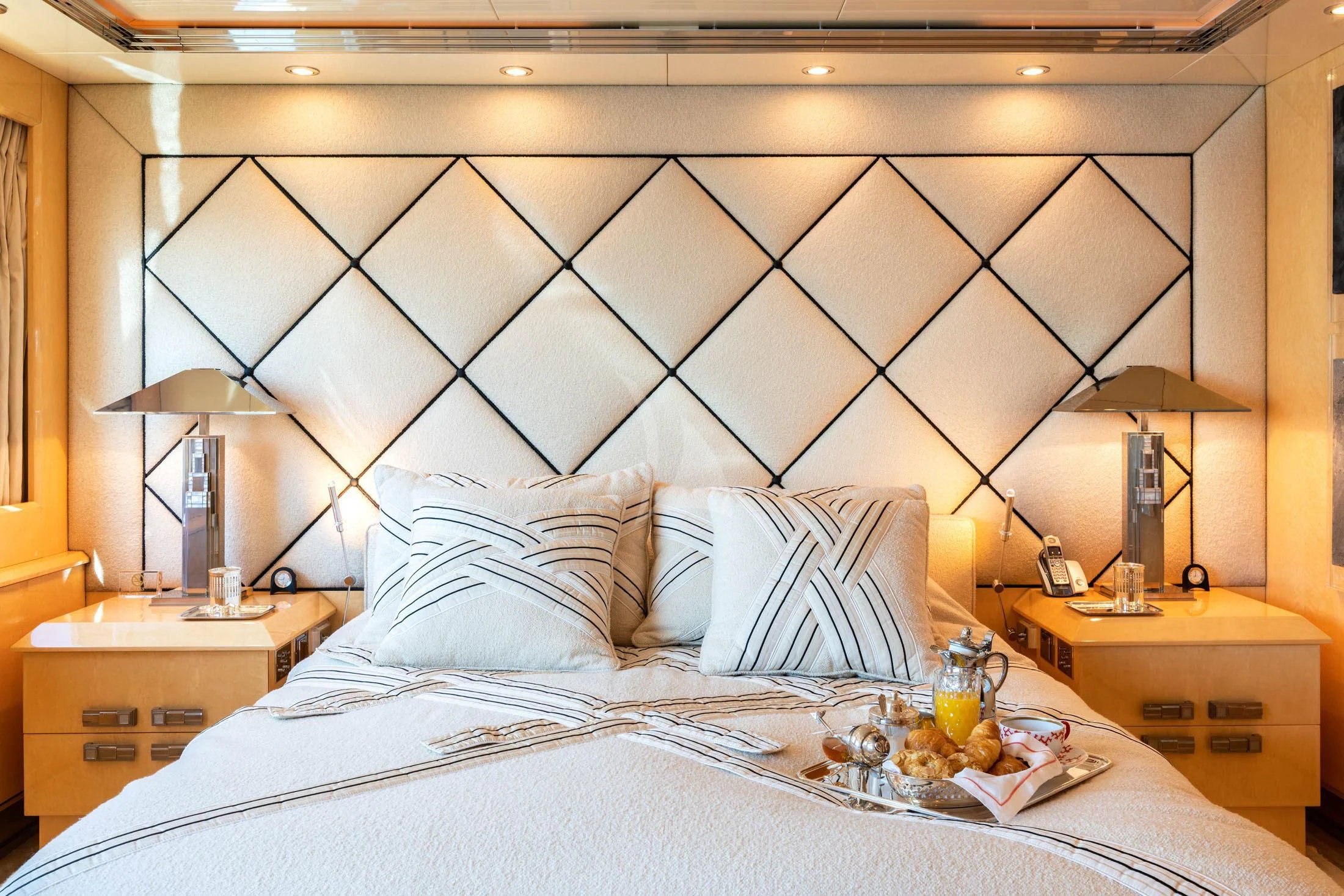 a bed with a tray of food aboard SUNDAY Yacht for Charter