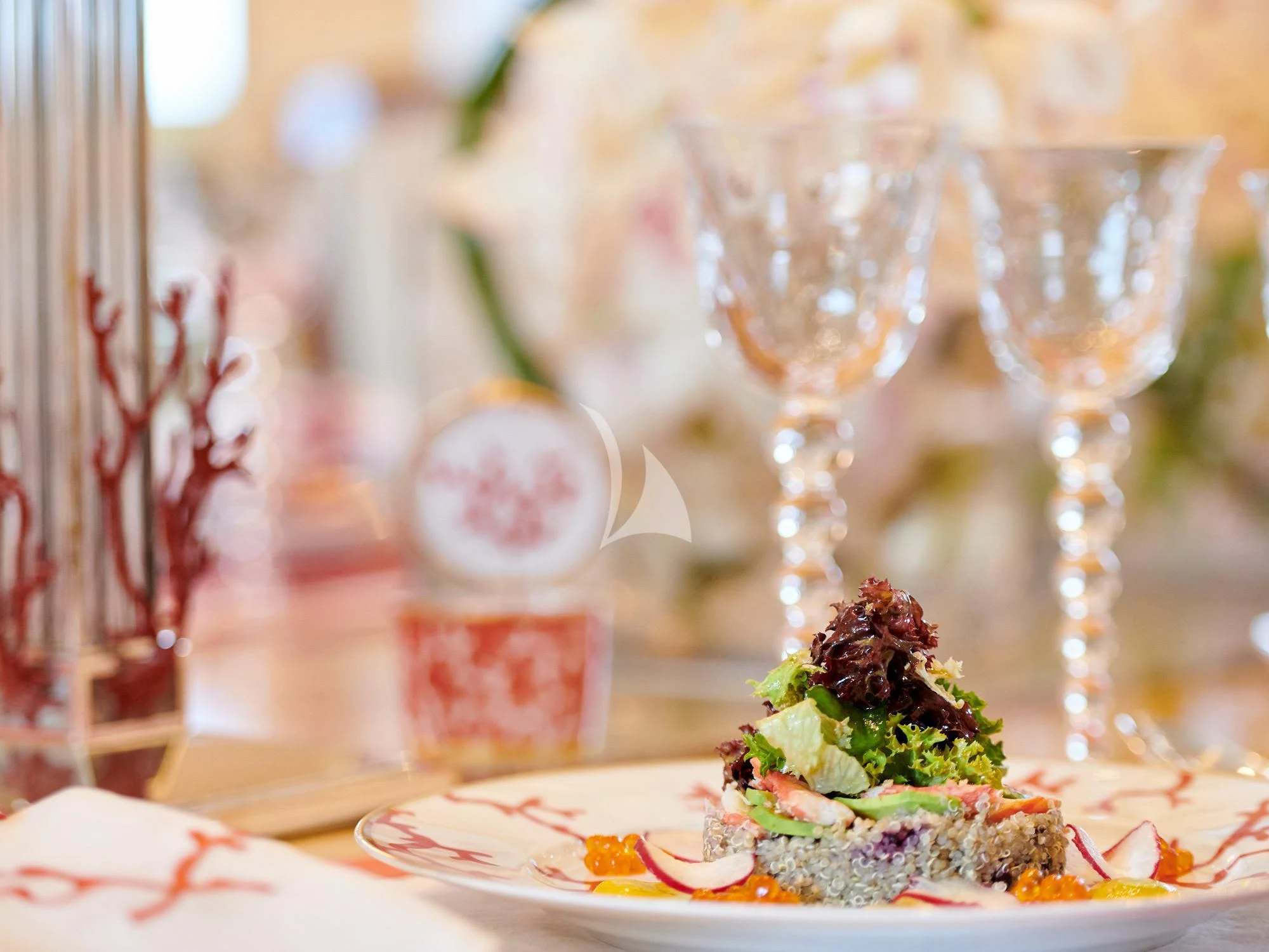 a table with a plate of food and glasses on it aboard SUNDAY Yacht for Charter