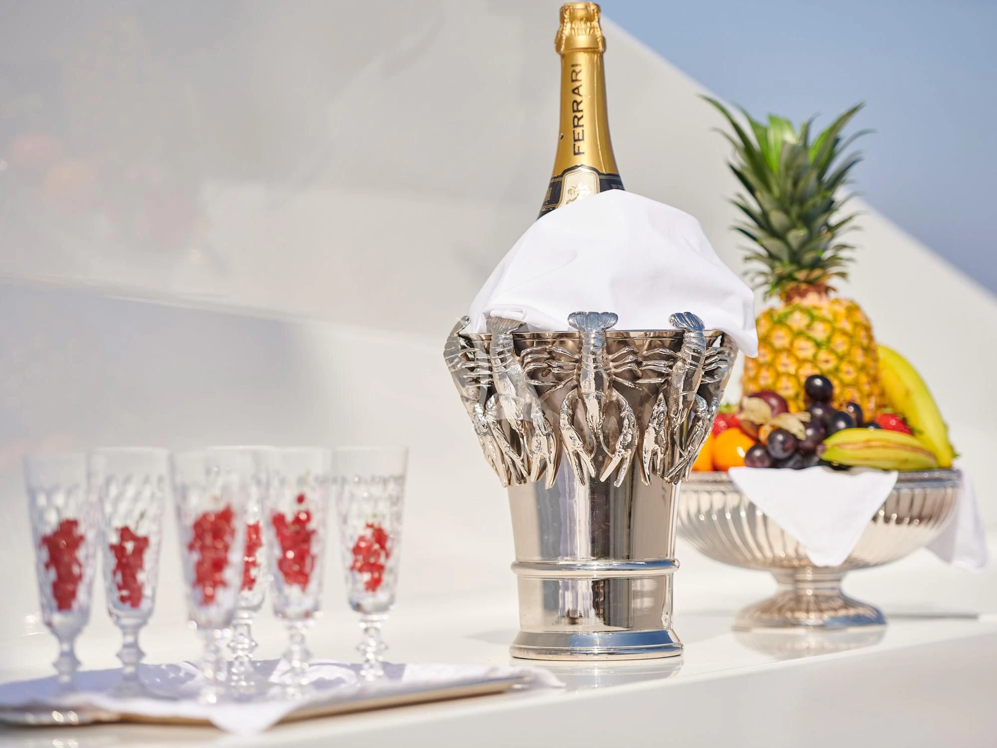 a glass of champagne with a fruit on the top aboard SUNDAY Yacht for Charter