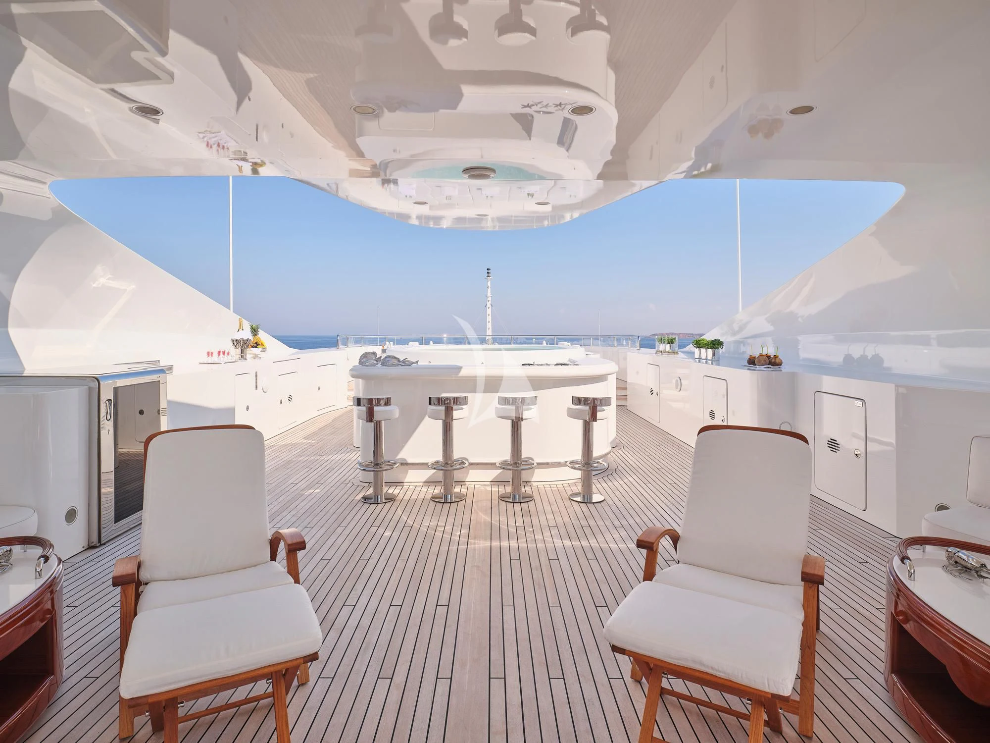 a room with a table chairs and a large blue pool in the background aboard SUNDAY Yacht for Charter