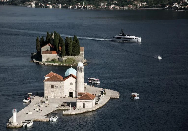 a small island with a lighthouse and boats in the water aboard AURORA Yacht for Sale
