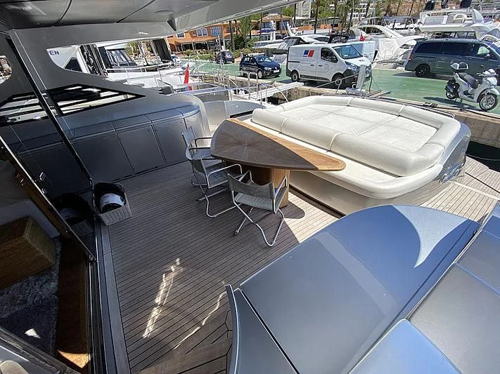 a table and chairs on a deck aboard MM Yacht for Sale