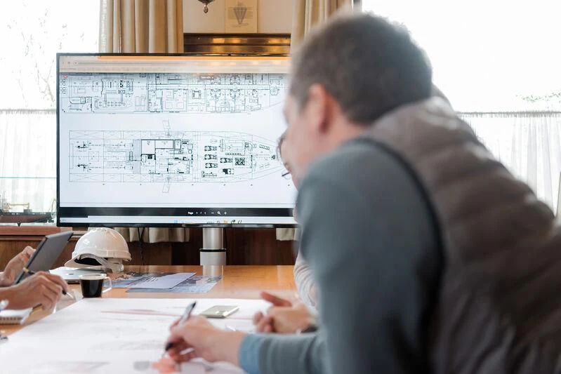 a man sitting at a desk in front of a computer screen aboard HORIZON II Yacht for Sale