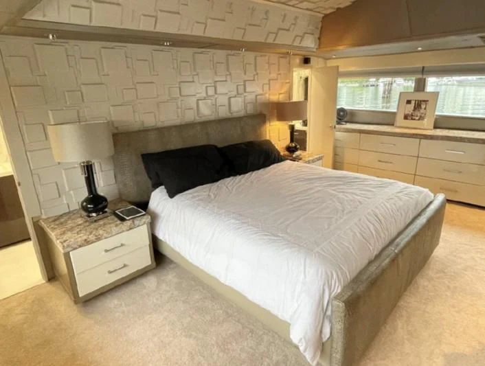 a bedroom with a bed and a desk aboard SOVEREIGN LADY Yacht for Sale