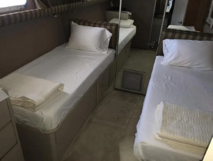 a room with beds and a window aboard SOVEREIGN LADY Yacht for Sale
