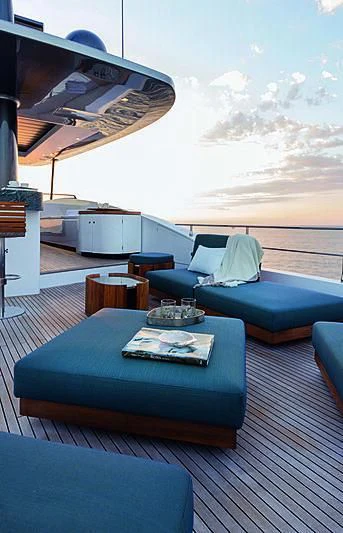 a deck with a table and chairs aboard JAKAT Yacht for Sale