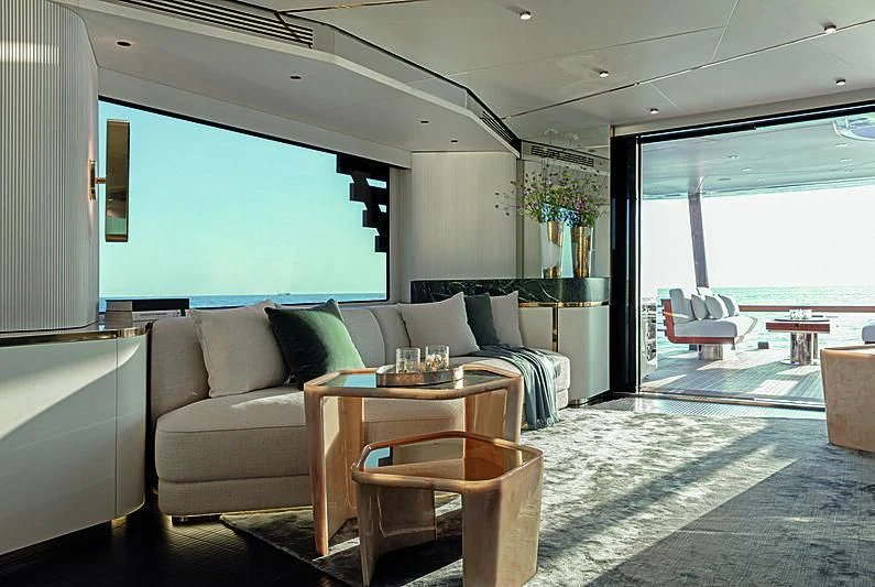 a living room with a couch and a table aboard JAKAT Yacht for Sale