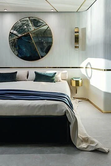 a bed with a blue sheet aboard JAKAT Yacht for Sale