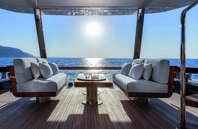 a room with a couch and a table and a pool aboard JAKAT Yacht for Sale