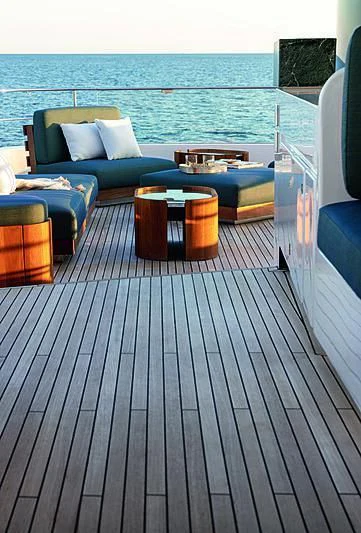 a deck with a couch and a table on it aboard JAKAT Yacht for Sale