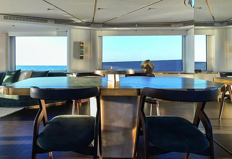 a room with a table and chairs aboard JAKAT Yacht for Sale