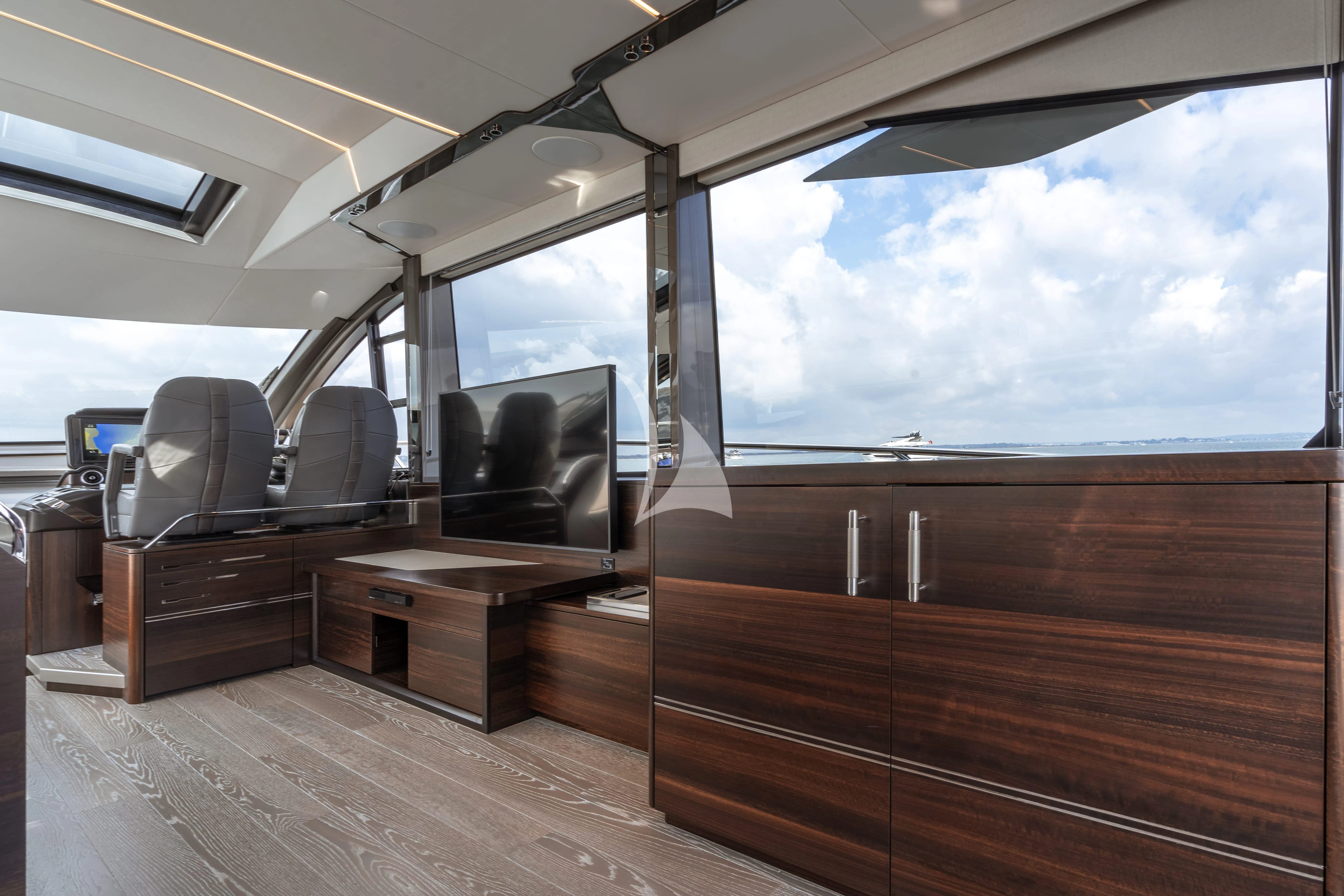 inside of a vehicle with a tv and a wood table and a large window with a view of aboard FIVE II Yacht for Sale