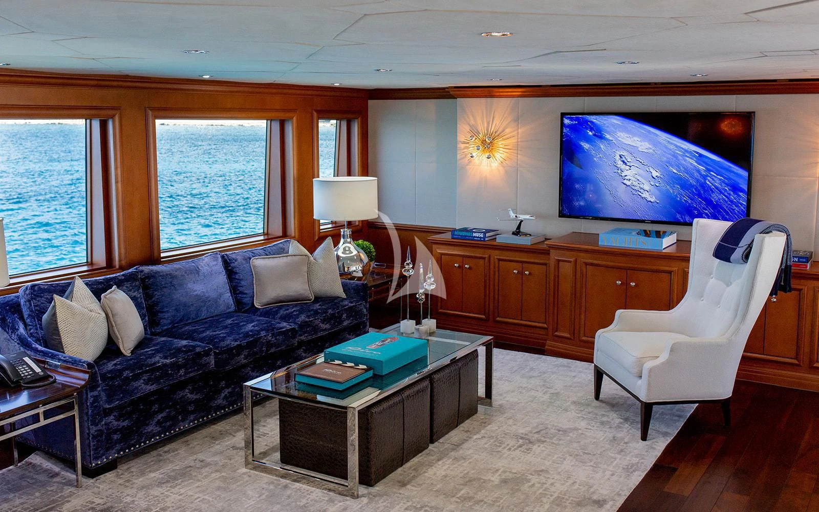 a living room with a blue couch aboard M3 Yacht for Sale