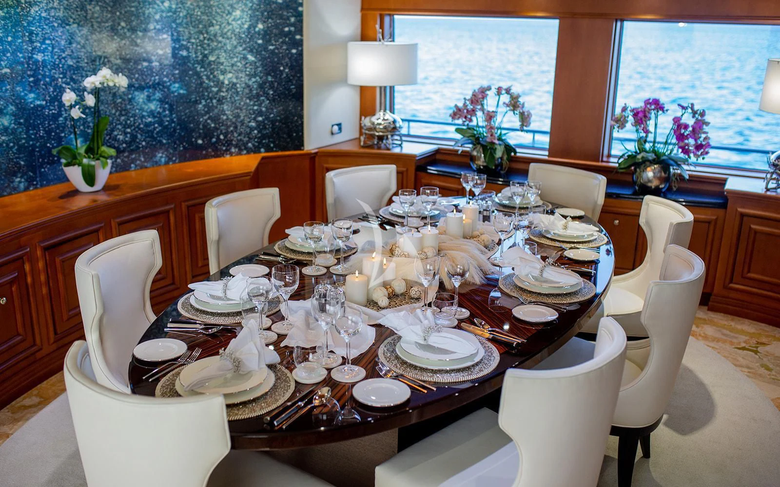 a table set with plates and chairs aboard M3 Yacht for Sale
