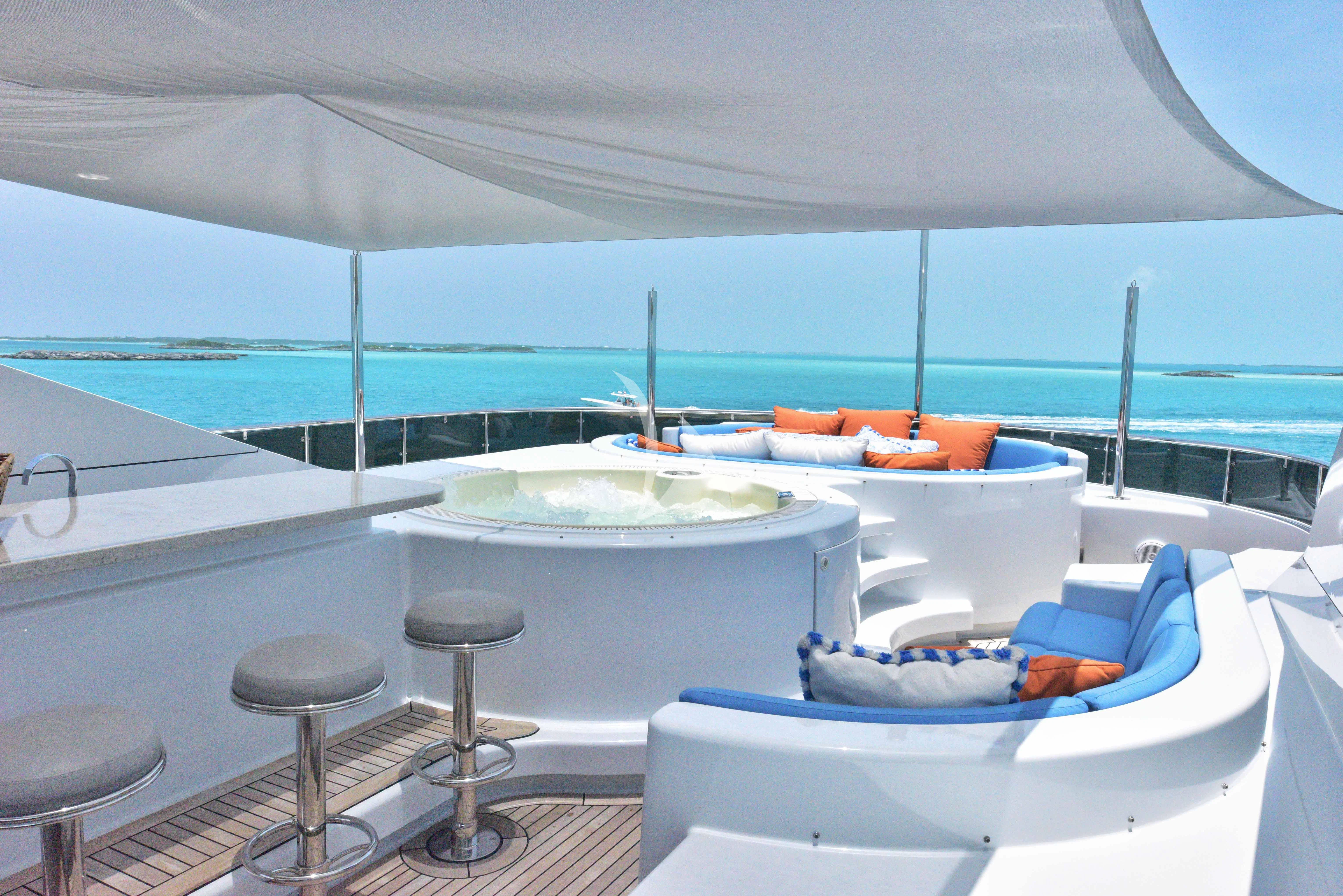 a large white lounge chair on a boat with a large body of water behind it aboard M3 Yacht for Sale