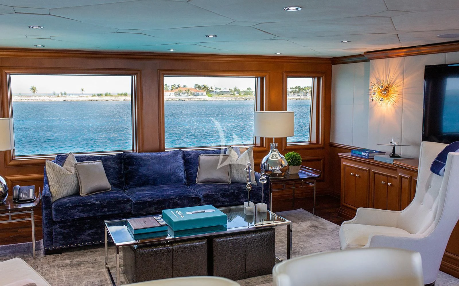 a living room with a blue couch aboard M3 Yacht for Sale