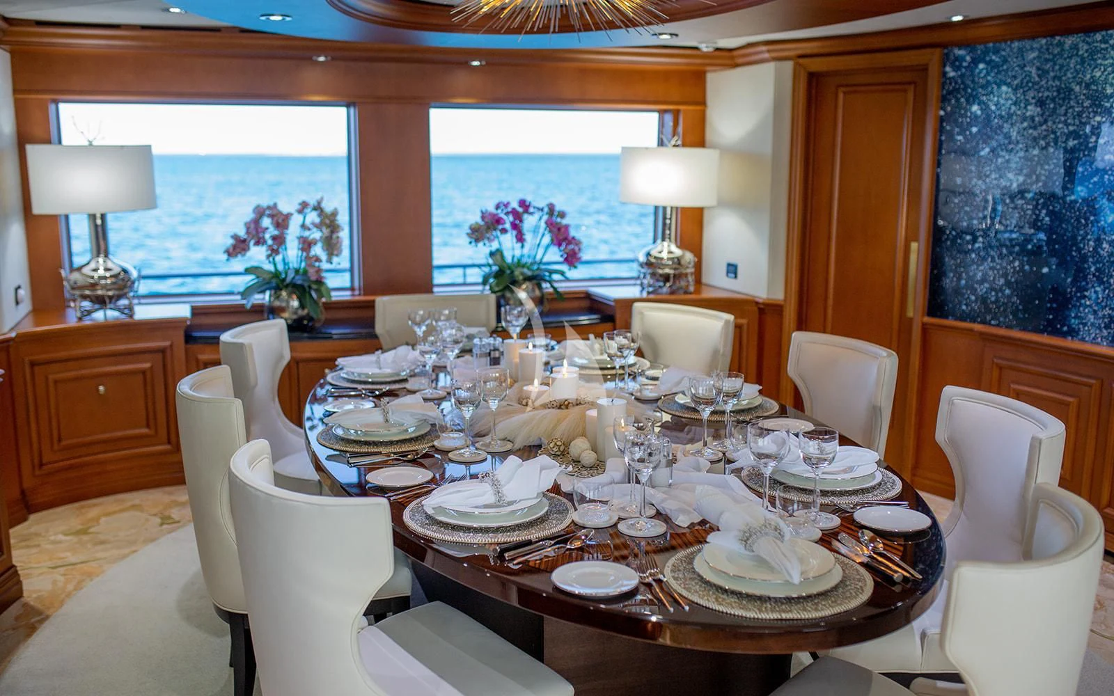 a dining room with white chairs and a large window aboard M3 Yacht for Sale