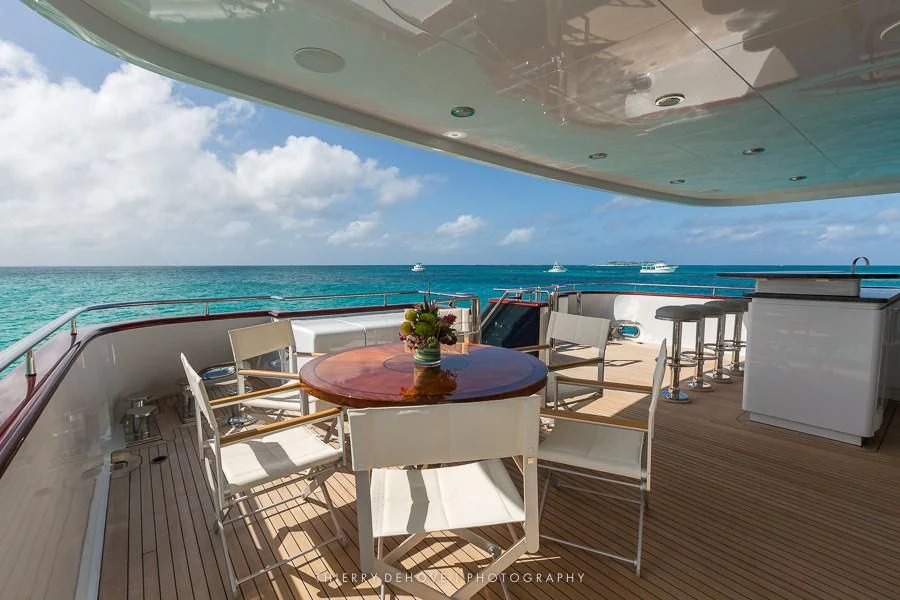 a balcony with a table and chairs on the deck aboard M3 Yacht for Sale