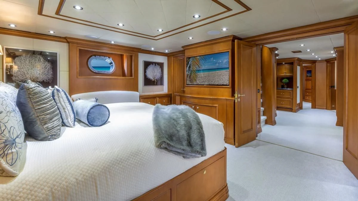 a room with a bed and a wood cabinet aboard M3 Yacht for Sale