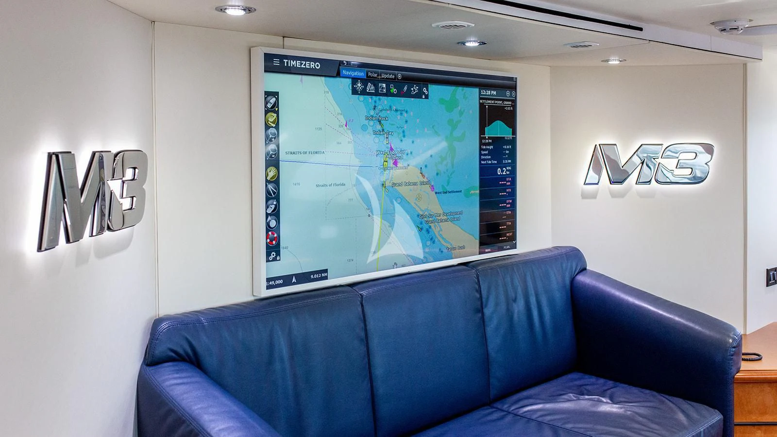 a blue couch in a room aboard M3 Yacht for Sale