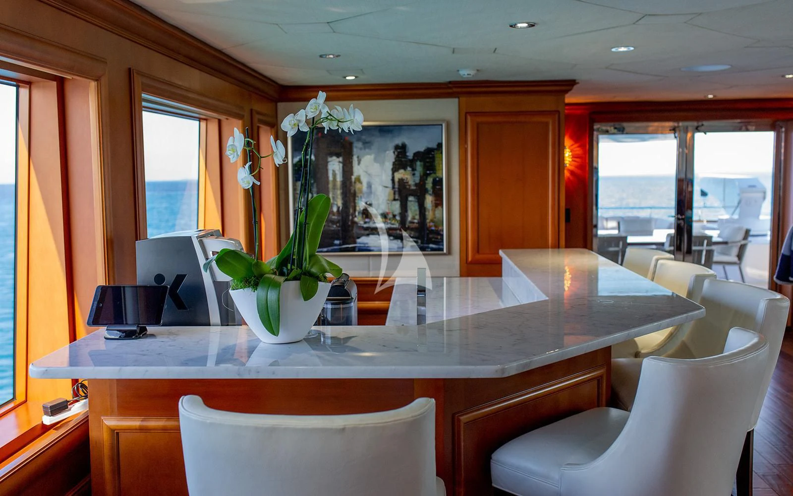 a table with chairs and a vase with flowers on it aboard M3 Yacht for Sale