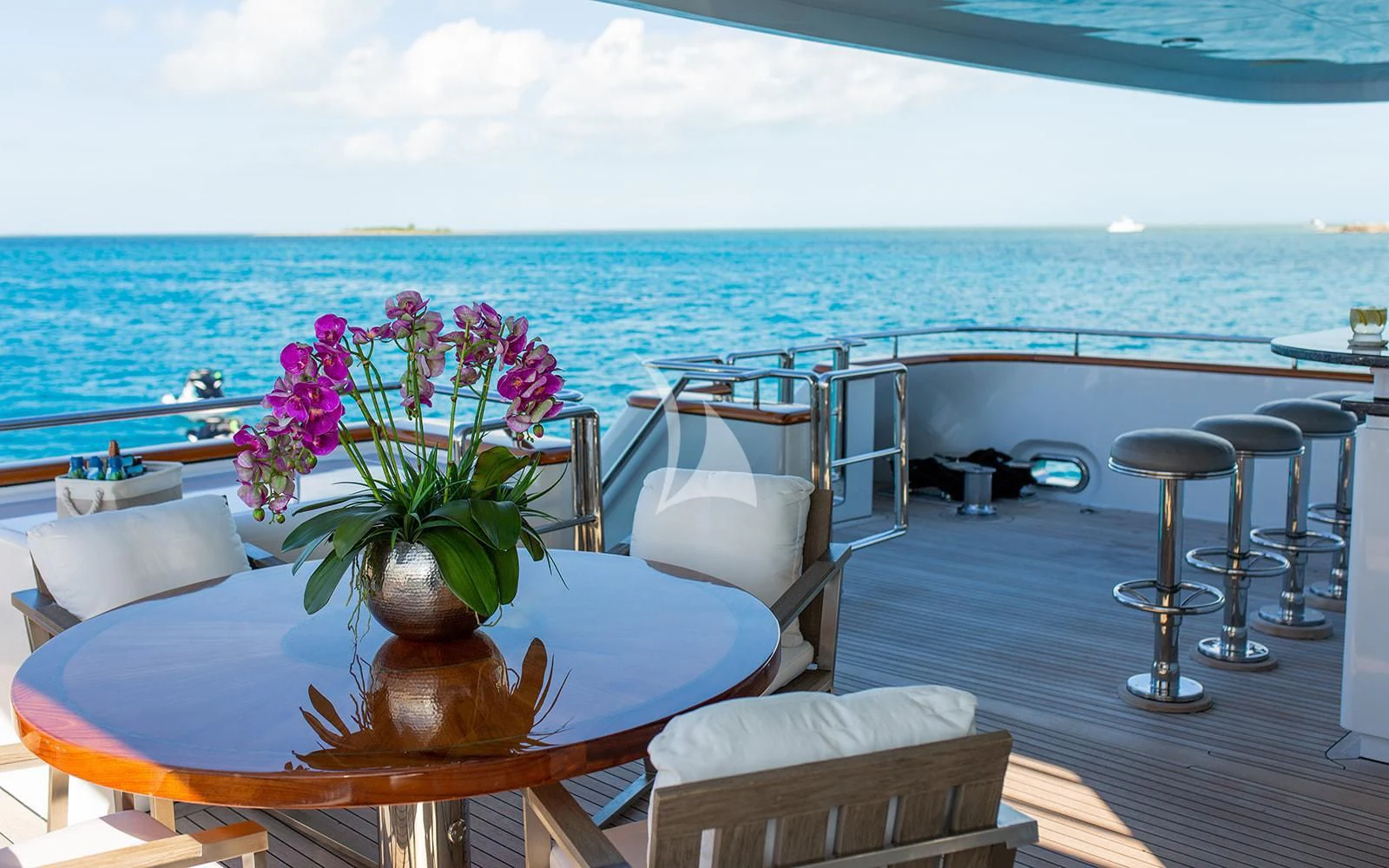 a table with chairs and a plant on it by the ocean aboard M3 Yacht for Sale