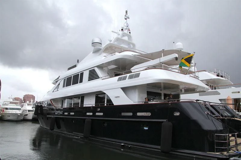 a large white boat with a yellow flag on it aboard M3 Yacht for Sale