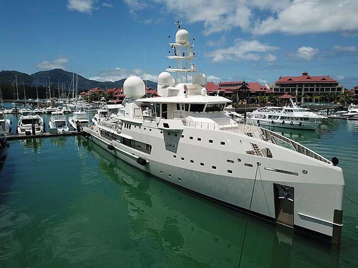 a large white boat in a harbor aboard UM ALHOUL Yacht for Sale